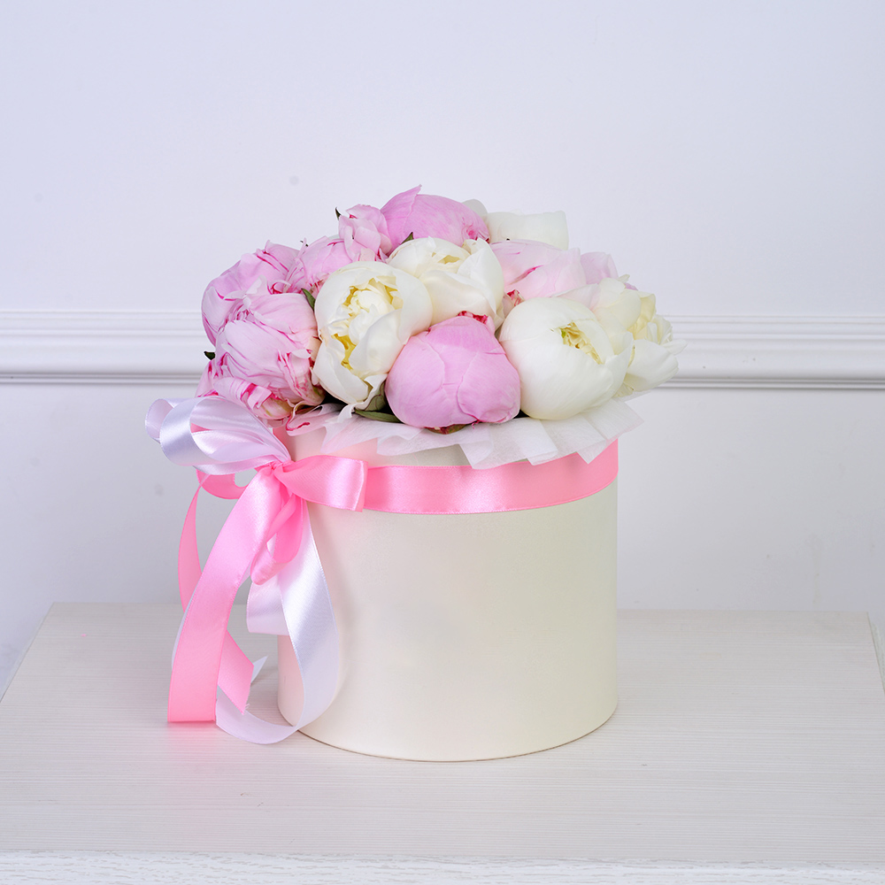 Букет из 11 разноцветных пионов в кремовой шляпной коробке