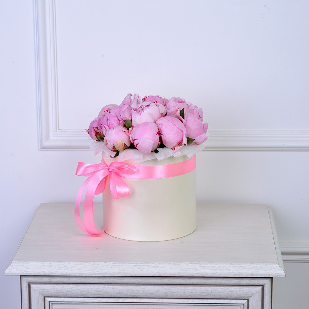 Букет из 15 розовых пионов в кремовой шляпной коробке